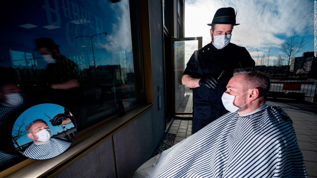 Abed Khankan cuts a customer&#39;s hair outdoors in Malmo, Sweden, on April 17.